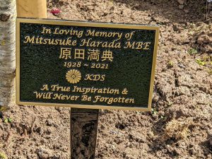 Sensei living memorial, a sign reads 'in loving memory of Mitsusuke Harada MBE, a true inspiration and will never be forgotten