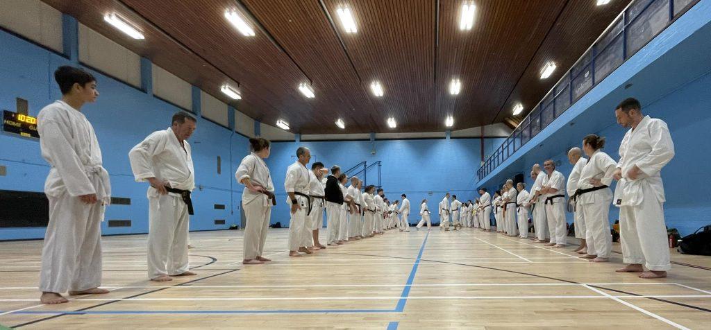 Students performing kata in a sports hall at a karate course
