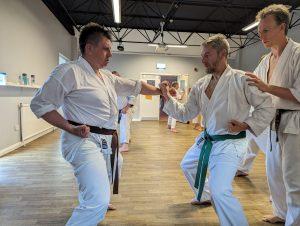 kds3 Instructor helping two men in karate kits
