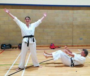 kds4 Woman in karate kit celebrating, man in karate kit on the floor laughing